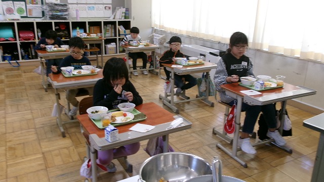 自分で選んだ給食を美味しそうに食べている児童たちの写真