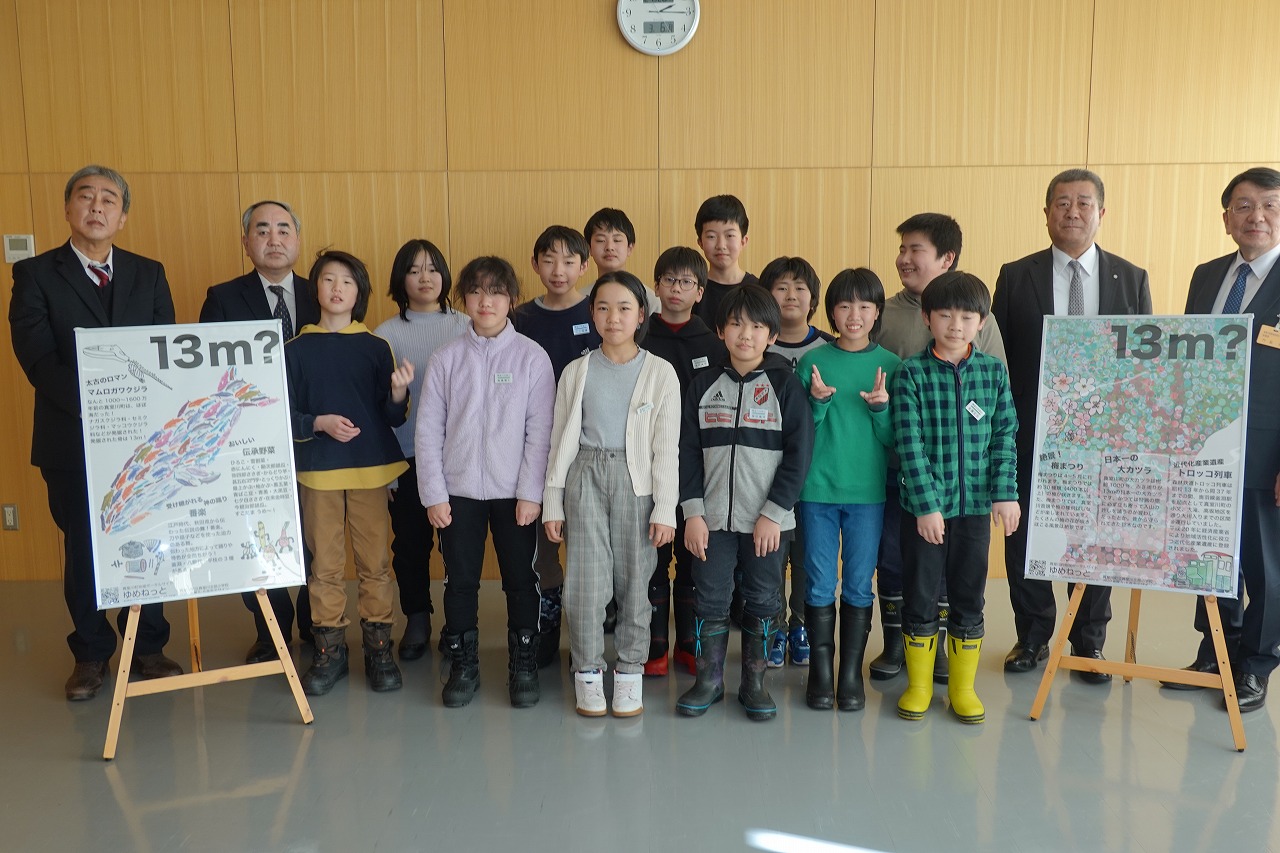 ポスターと共に整列した、町長、教育長と北部小学校の代表の記念写真