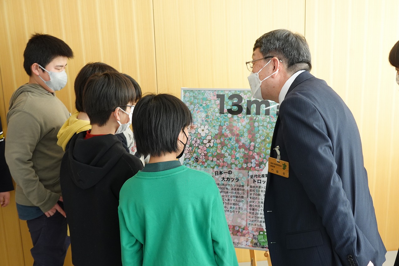 ポスターの前で北部小学校の代表に声を掛ける教育長の写真