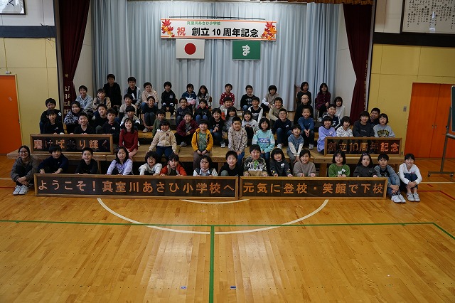 10周年記念銅板プレートと生徒たちと先生たちの記念写真