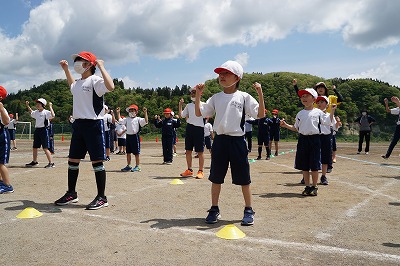 集合して体操をする児童たちの写真