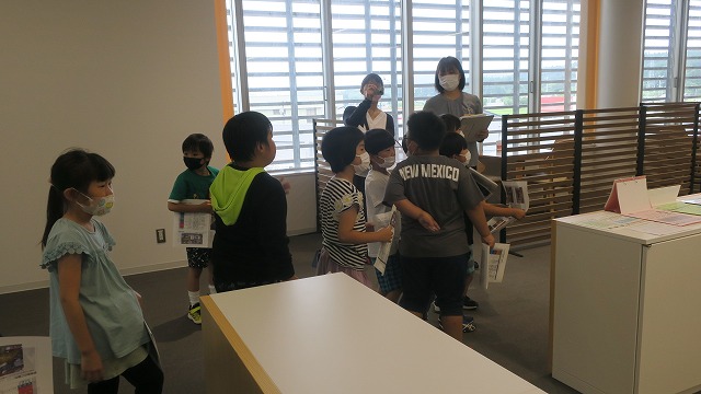 真室川町役場の職員の説明を聞く児童たちの写真