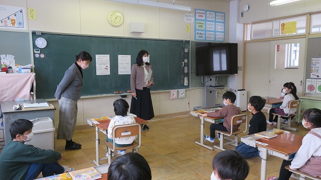 教室で席に着き、小学校の先生の話を興味深そうに聴く、新入児童たちの写真