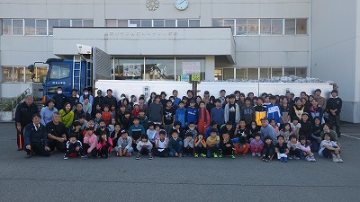 活動参加者全員が大きなトラックの前に集まって撮影した集合写真