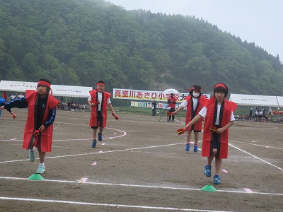 紅い法被を着てダンスをする児童たちの写真