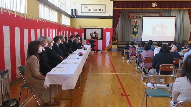 ビデオを見る保護者と先生と生徒たちの写真