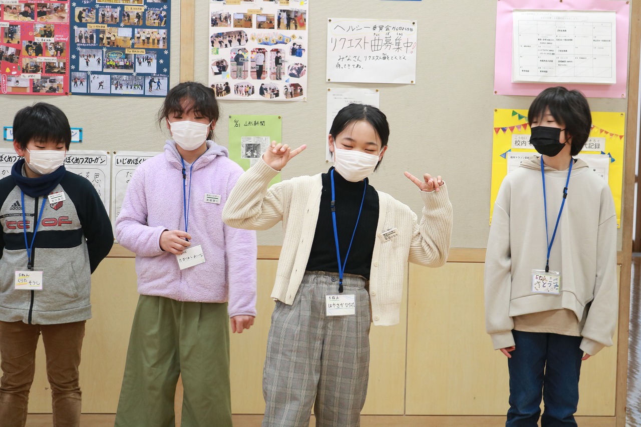 小学校の教室内で行われた新入生体験入学にて、教室の掲示板の前に立っている、男子児童2人と女子児童2人の様子を写した写真