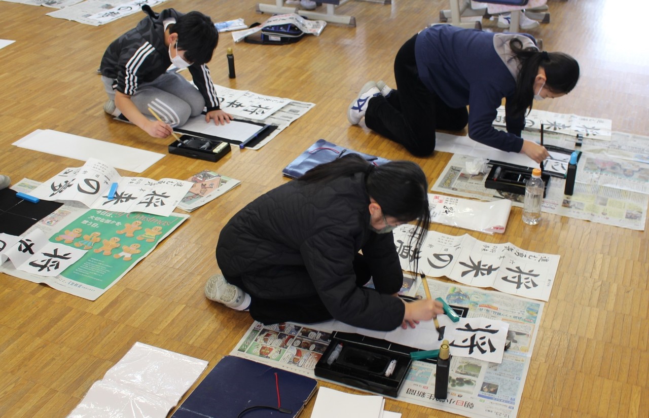 「将来の夢」という文字を筆で書く子供たちの写真