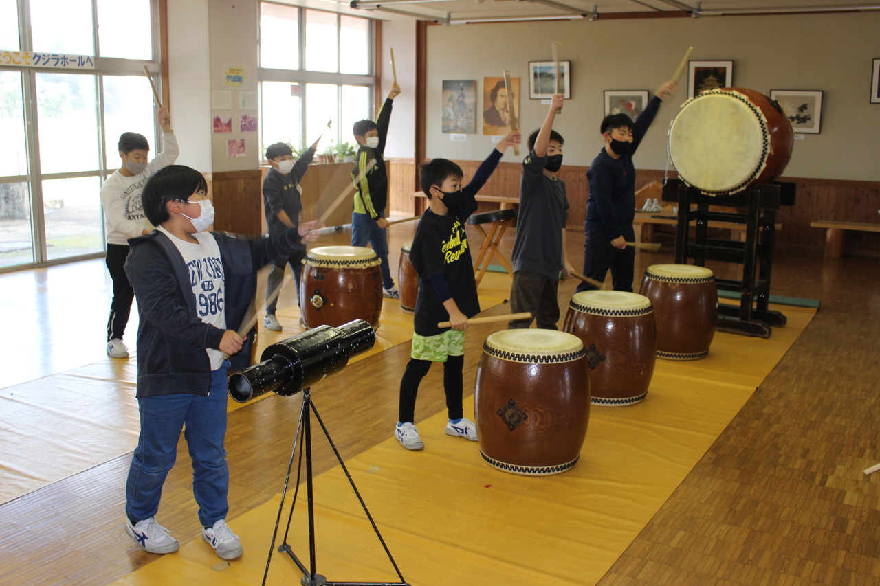 和太鼓のばちを大きく掲げる子供たちの写真
