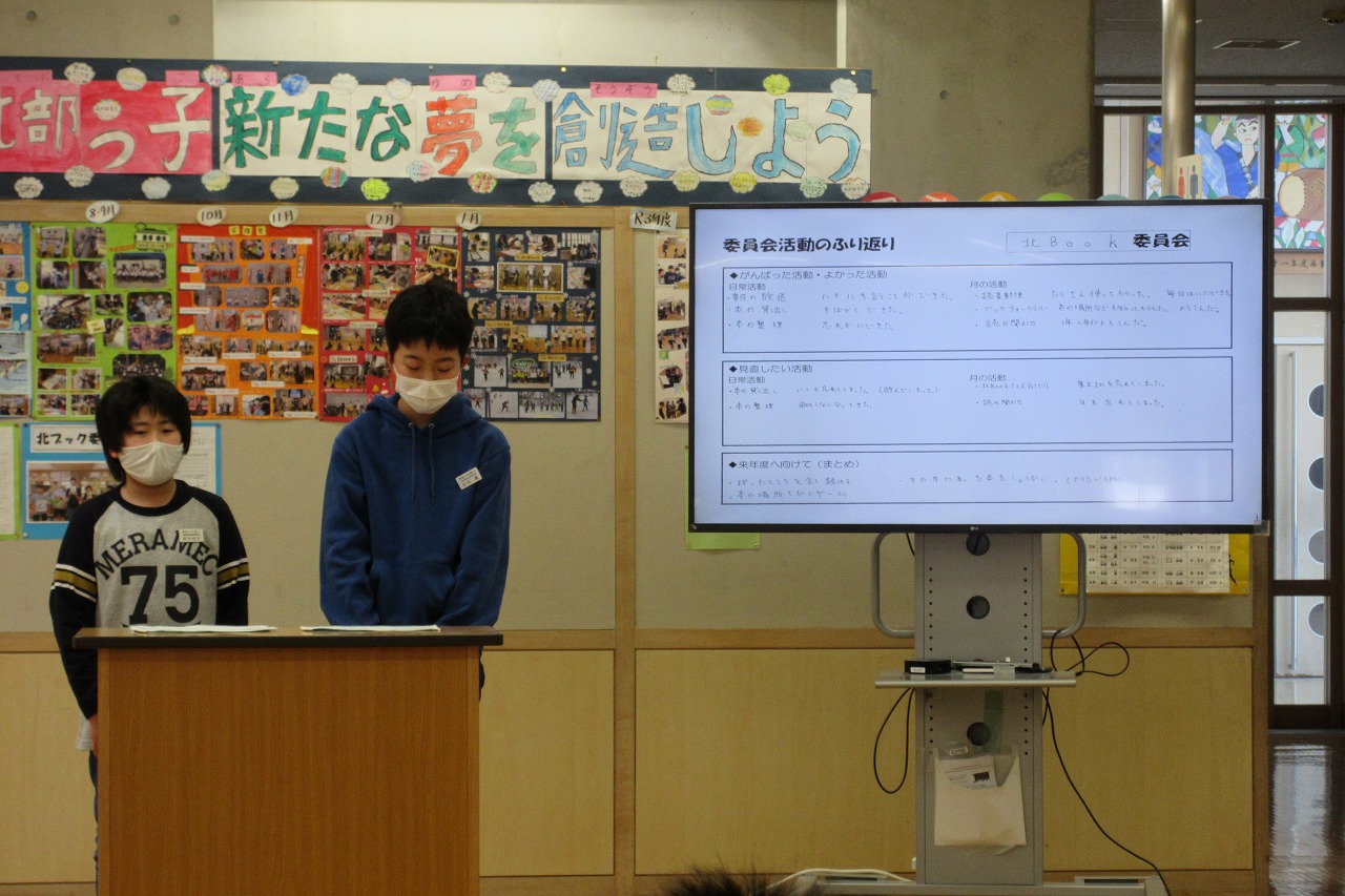 モニターを使って委員会活動について説明する2人の委員の写真