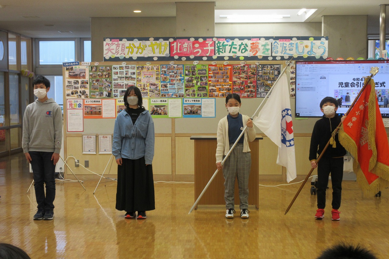 引き継がれた旗を持ちながら横一列に並ぶ前委員と次期委員の写真