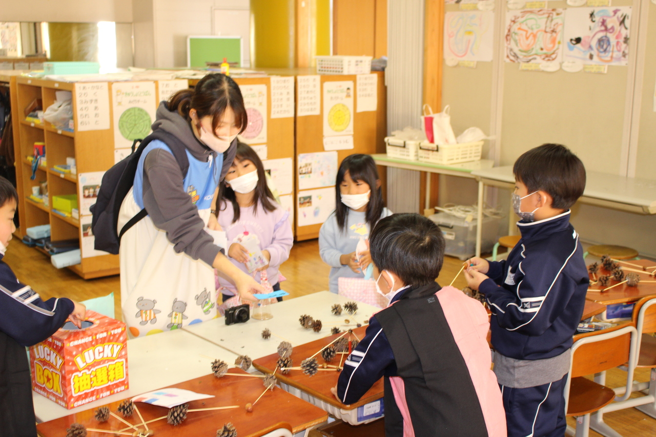 松ぼっくりで作ったおもちゃを買おうとしている女の人の写真