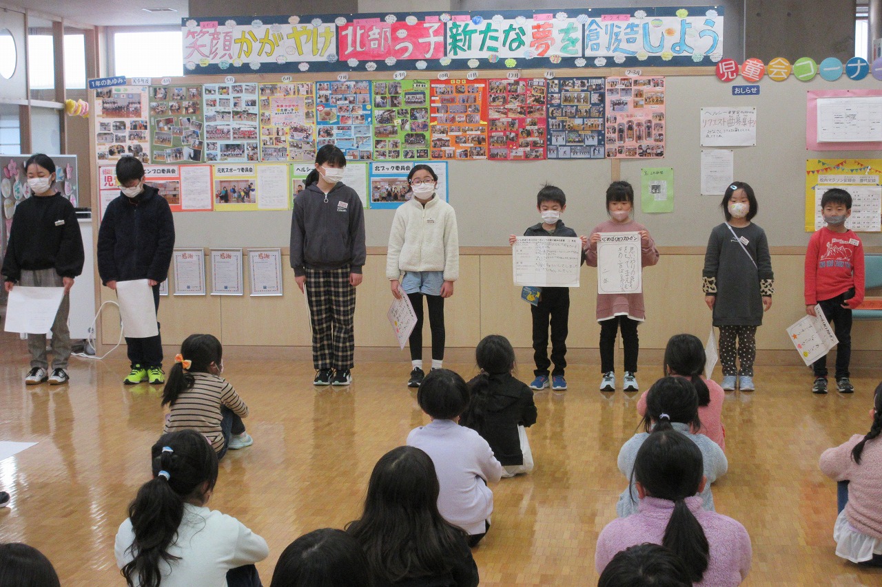 各学級の代表児童が前に出て、いじめぼくめつスローガンについて発表を行っている様子の写真