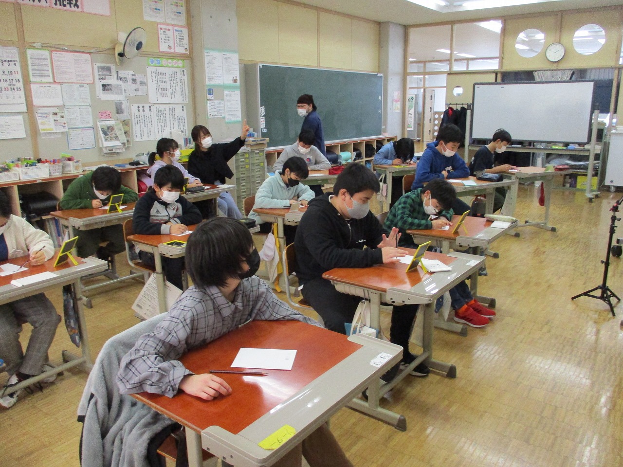 似顔絵教室で鏡を使って自分の似顔絵を描く5・6年の児童たちの写真