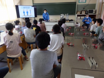 理科室で、東北電力の先生の話を聴く高学年児童たちの写真