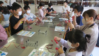 理科室の実験台で発電の準備をする高学年児童たちの写真