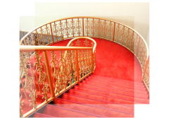 金色の装飾つきの手すりと赤い絨毯の階段の写真