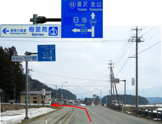 道路標識の写真、赤い矢印が書き込まれ左折するよう示している道路の写真の二枚が並んでいる写真