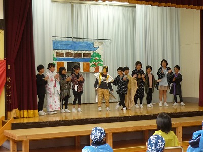 昔風の着物を着てわらしべ長者を演じる2年生児童たちの写真