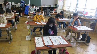 書き初めをする2年生の生徒たちの写真