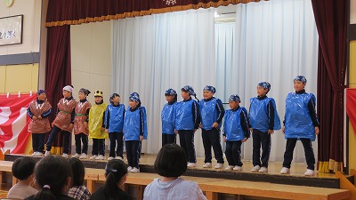 青や黄色のビニール袋を使った舞台衣装で王様と九人のきょうだいを演じる3年生児童たちの写真