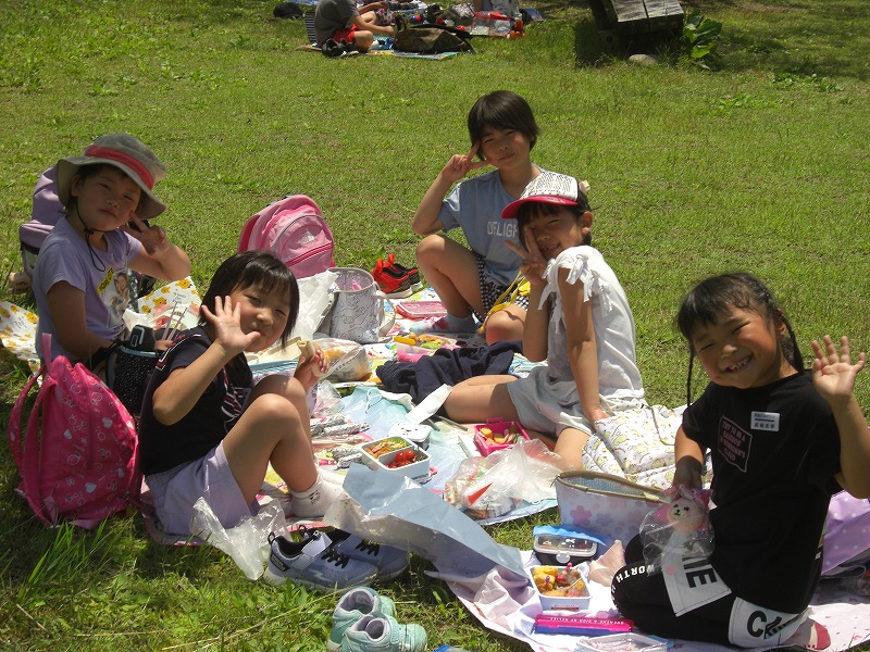 シートに座りお弁当を食べて、ご機嫌でこちらに手を振る女子児童たちの写真