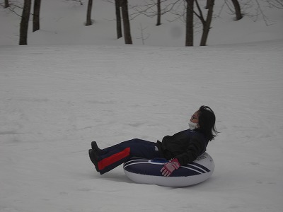 雪の上でチューブ乗りする女の子の写真