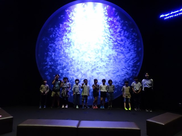 クラゲドリームシアターの水槽の前で撮影した児童たちの集合写真