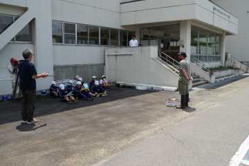 前に立って話す講師と座って聞く生徒たちの写真