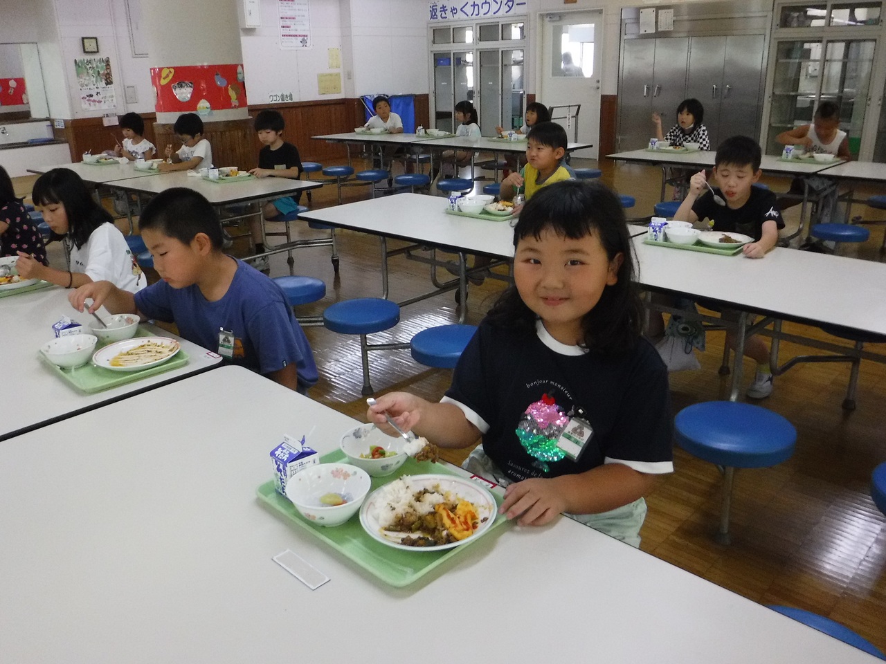 給食を食べて、にっこりしている子供たちの写真