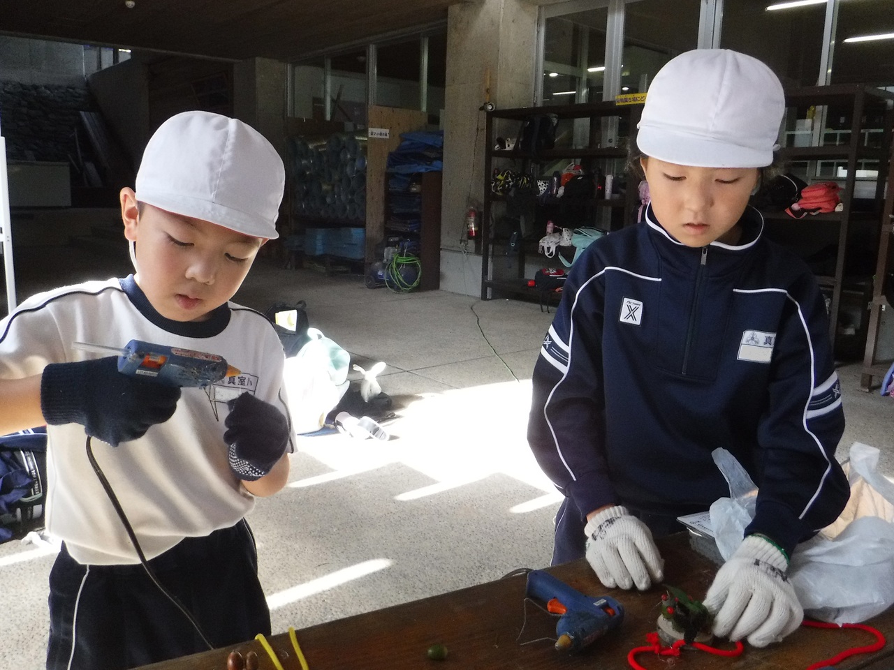 グルーガンをつかって工作をしている子供たちの写真