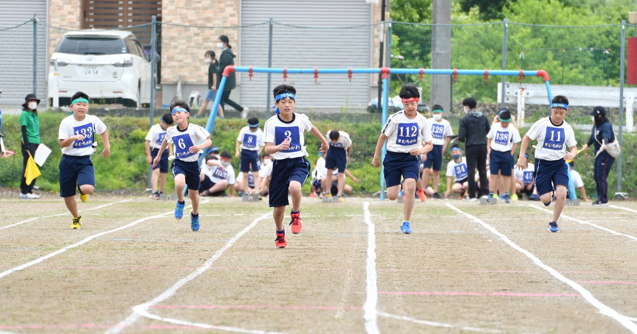 鉢巻を巻いた体操服姿の5人の男子がまっすぐ走ってきている写真