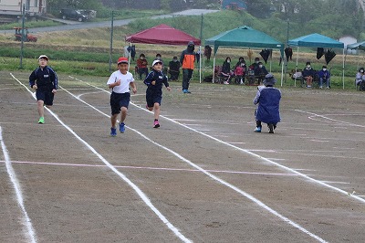 徒競走で全力疾走する児童たちの写真
