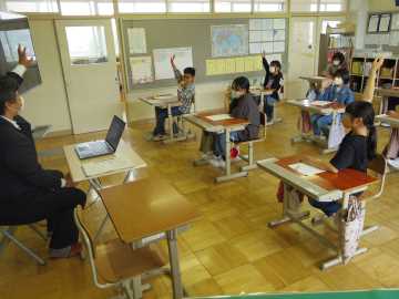 手を挙げて先生に質問をする児童たちの写真
