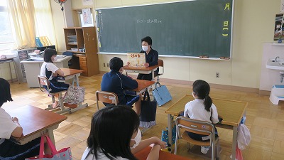 椅子に腰かけ、じっくりと読み聞かせをして下さる女性の写真