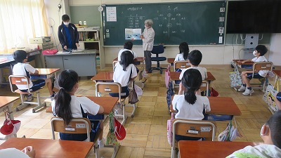 読み聞かせに熱心に聴き入る、椅子に座った児童たちの写真
