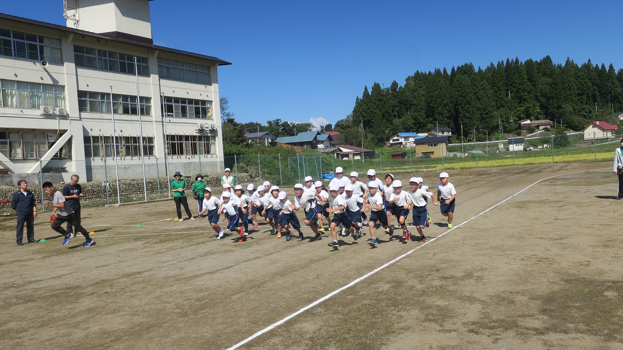 持久走記録会で低学年の児童たちが一斉にスタートを切る様子の写真
