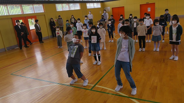 大きくのけぞるような姿勢で声を張り上げて応援する生徒たちの写真