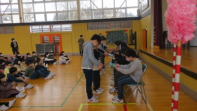 4年生の方々から贈り物を受け取る6年生たちの写真