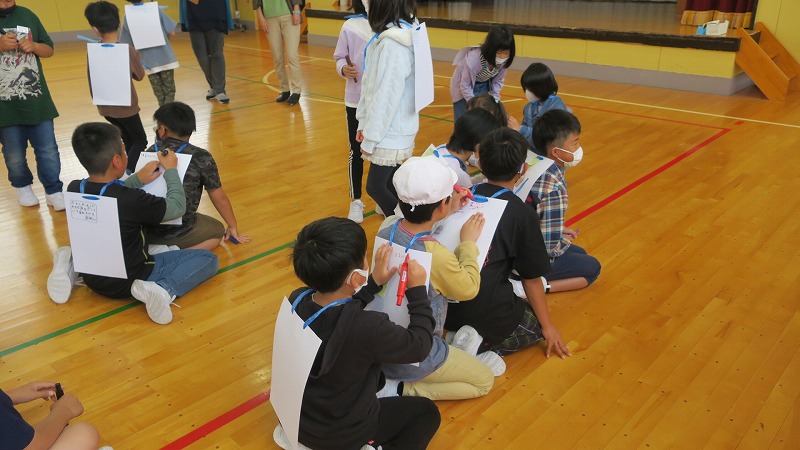 一列になり、前にいる人の背中に、運動会で良かったところを書いている様子の写真
