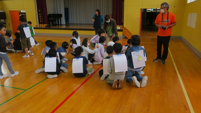 次々に友達の背中に良かったところを書く児童たちの写真