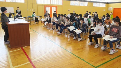 本を開きながら児童会総会を行う児童たちの写真