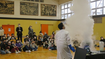 白衣の男性が、白い煙を大量に発生させている写真