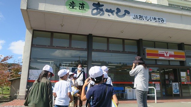産直あさひの入口前にいる生徒たちと先生の写真