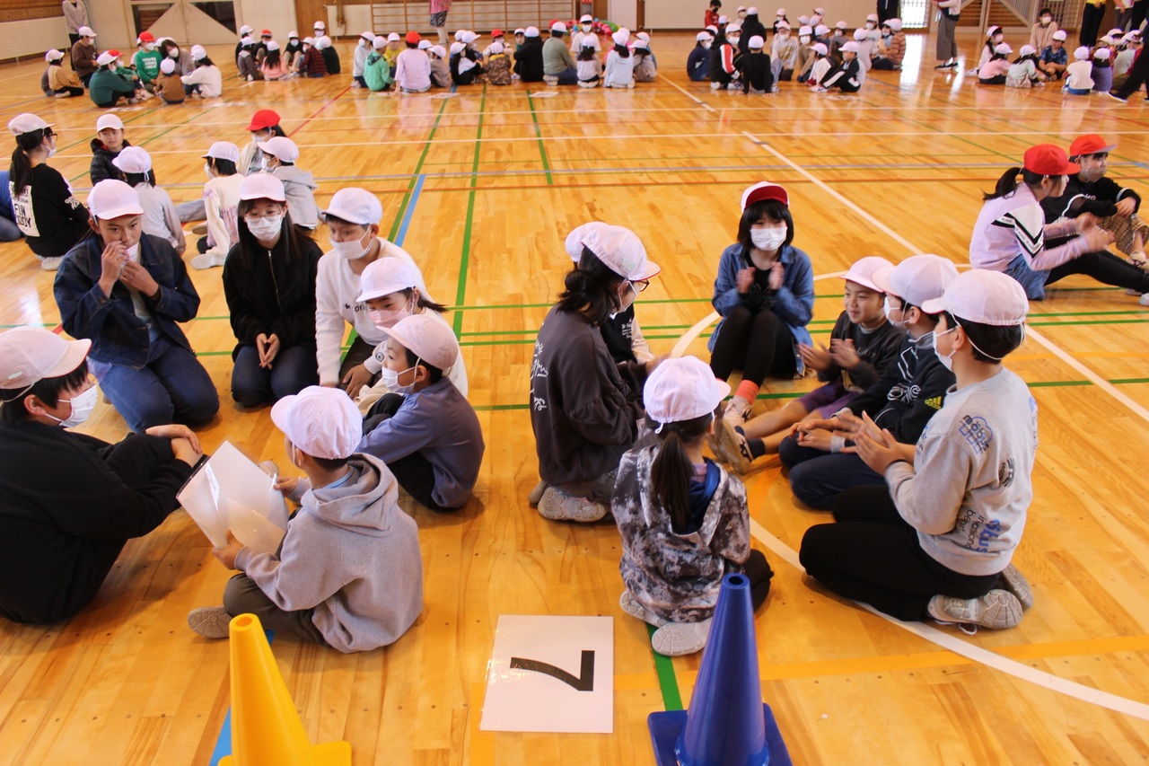 円陣になって座り話をする子供たちの写真