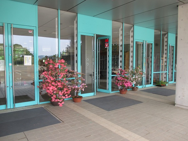 エントランスの外に満開の花の鉢が置かれている写真