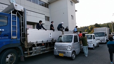 新聞・雑誌回収トラックに回収してきた資源を載せ替えている活動参加者たちの写真