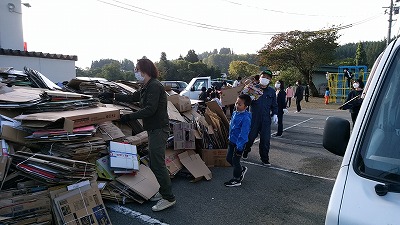 回収されてきたたくさんのダンボールを回収場所に積み上げている写真