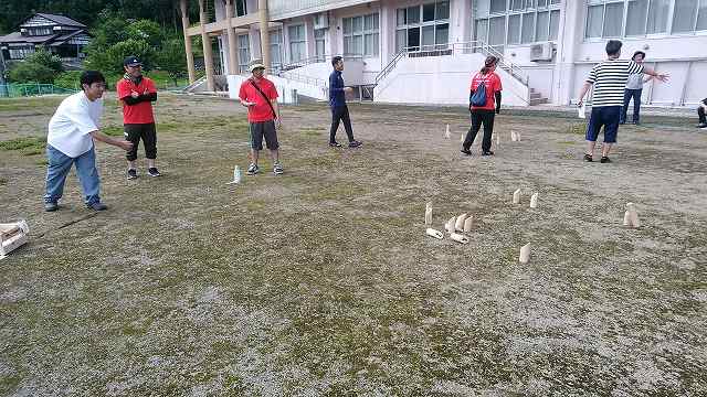 芝生の上で初めてのモルックを楽しむ参加者たちの写真