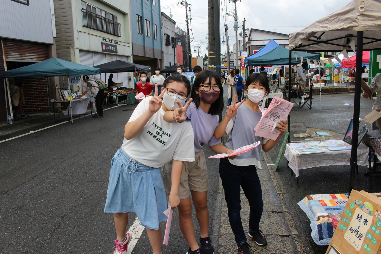 カメラに向かってピースサインをする女子児童三人の写真
